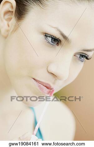 Close-up of a young woman applying lip liner View Large Photo Image Stock Image - Close-up of a young woman applying lip liner. Fotosearch