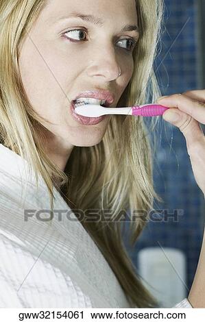 Close-up of a young woman brushing her teeth View Large Photo Image Stock Image - Close-up of a young woman brushing her teeth. Fotosearch
