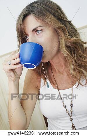 Close-up of a young woman drinking a cup of tea View Large Photo Image Stock Image - Close-up of a young woman drinking a cup of tea. Fotosearch