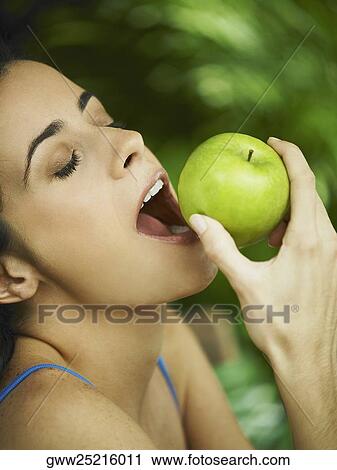 Close-up of a young woman eating an apple View Large Photo Image Stock Image - Close-up of a young woman eating an apple. Fotosearch