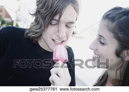 Close-up of a young woman feeding an ice-cream to a teenage boy View Large Photo Image Stock Image - Close-up of a young woman feeding an ice-cream to a teenage boy. Fotosearch