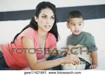 Close-up of a young woman feeding her son popcorn View Large Photo Image Stock Image - Close-up of a young woman feeding her son popcorn. Fotosearch