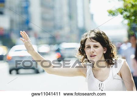 Close-up of a young woman hailing a taxi View Large Photo Image Stock Image - Close-up of a young woman hailing a taxi. Fotosearch