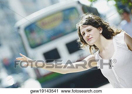 Close-up of a young woman hailing a taxi View Large Photo Image Stock Image - Close-up of a young woman hailing a taxi. Fotosearch