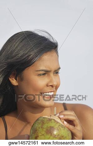 Close-up of a young woman holding a coconut View Large Photo Image Stock Image - Close-up of a young woman holding a coconut. Fotosearch