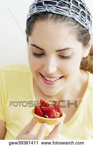 Close-up of a young woman looking at a strawberry tart View Large Photo Image Stock Image - Close-up of a young woman looking at a strawberry tart. Fotosearch