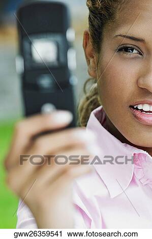 Close-up of a young woman taking a picture of herself with a mobile phone View Large Photo Image Stock Image - Close-up of a young woman taking a picture of herself with a mobile phone. Fotosearch
