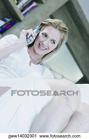 Close-up of a young woman talking on a cordless phone View Large Photo Image Stock Image - Close-up of a young woman talking on a cordless phone. Fotosearch