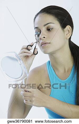 Close-up of a young woman using eyelash curlers View Large Photo Image Stock Image - Close-up of a young woman using eyelash curlers. Fotosearch
