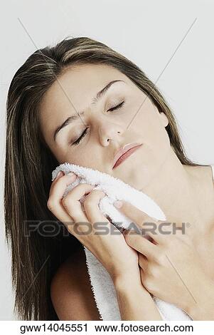 Close-up of a young woman wiping her face with a towel View Large Photo Image Stock Image - Close-up of a young woman wiping her face with a towel. Fotosearch