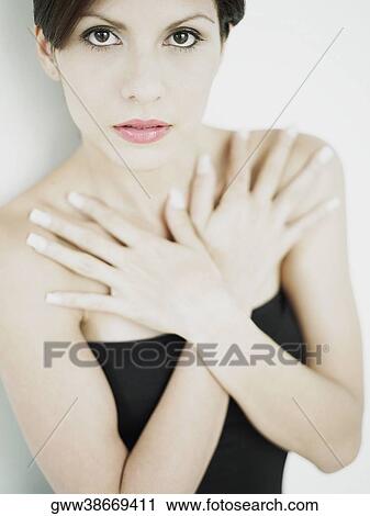 Stock Image - Close-up of a young woman with her hands on her chest. Fotosearch