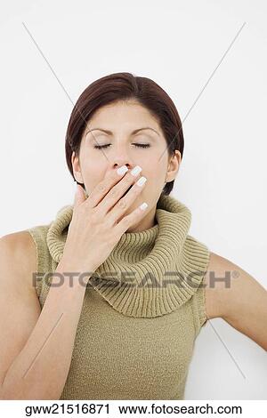 Stock Image - Close-up of a young woman yawning. Fotosearch