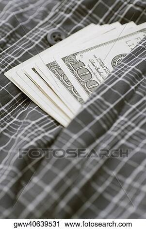 Stock Image - Close-up of American one hundred dollar bills with a checked cloth. Fotosearch