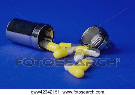 Stock Image - Close-up of an open pill bottle with capsules. Fotosearch