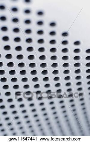 Stock Image - Close-up of holes on a metal surface. Fotosearch