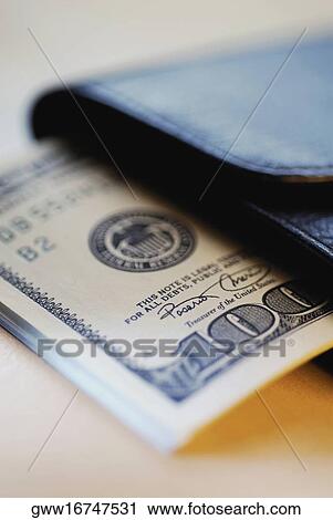 Stock Image - Close-up of one hundred dollar note with a wallet. Fotosearch
