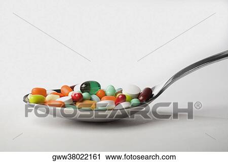 Stock Image - Close-up of pills in a spoon. Fotosearch