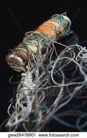 Stock Image - Close-up of tangled thread with a spool. Fotosearch