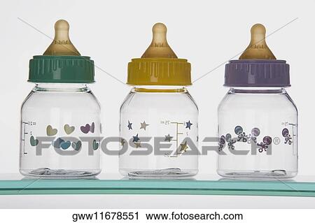 Close-up of three baby bottles on a shelf View Large Photo Image Stock Image - Close-up of three baby bottles on a shelf. Fotosearch