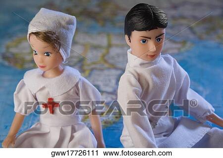 Stock Image - Close-up of two dolls sitting on a map. Fotosearch