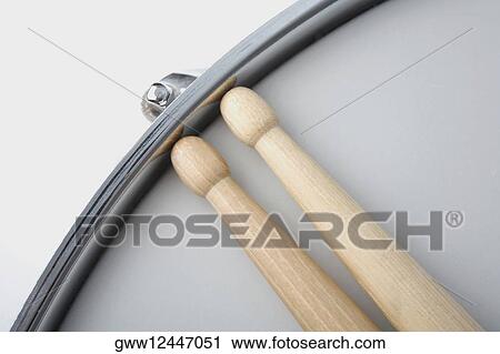 Stock Image - Close-up of two drumsticks with a drum. Fotosearch