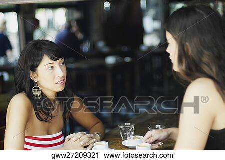 Close-up of two mid adult women sitting together and talking View Large Photo Image Stock Image - Close-up of two mid adult women sitting together and talking. Fotosearch