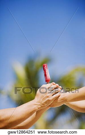 Close-up of two people's hands holding an ice-cream View Large Photo Image Stock Image - Close-up of two people's hands holding an ice-cream. Fotosearch