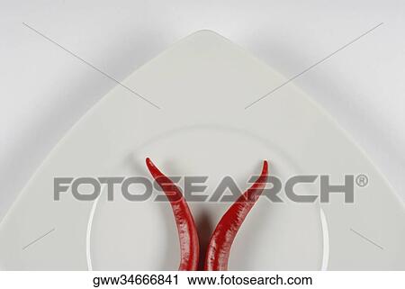 Close-up of two red chili peppers in a plate View Large Photo Image Stock Image - Close-up of two red chili peppers in a plate. Fotosearch