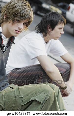Stock Image - Close-up of two teenage boys sitting together. Fotosearch