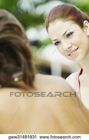 Stock Image - Close-up of two young women face to face. Fotosearch