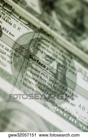 Stock Image - Close-up of weight conversion table over US paper currency. Fotosearch