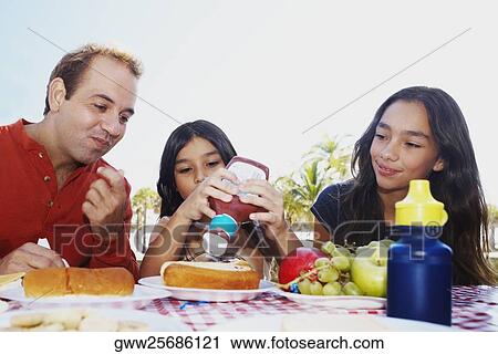Girl squeezing ketchup from a bottle on a hot dog View Large Photo Image Stock Image - Girl squeezing ketchup from a bottle on a hot dog. Fotosearch
