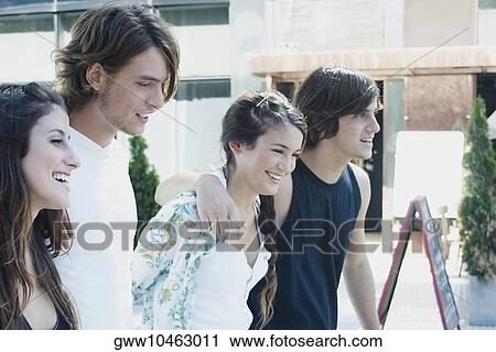 Stock Image - Group of friends walking together with their arms around each other. Fotosearch