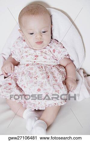 Stock Image - High angle view of a baby girl lying on her back. Fotosearch