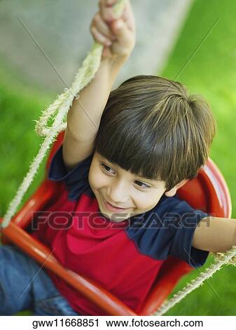 High angle view of a boy on a swing View Large Photo Image Stock Image - High angle view of a boy on a swing. Fotosearch