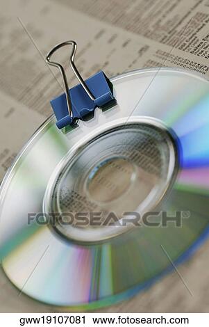 Stock Image - High angle view of a CD with a binder clip on a stock market data sheet. Fotosearch