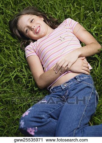High angle view of a girl lying on the grass View Large Photo Image Stock Image - High angle view of a girl lying on the grass. Fotosearch