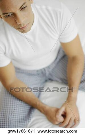 High angle view of a mid adult man sitting on the bed View Large Photo Image Stock Image - High angle view of a mid adult man sitting on the bed. Fotosearch