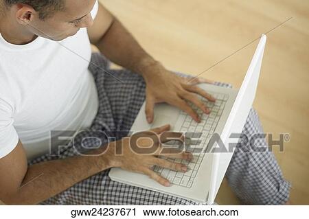 High angle view of a mid adult man using a laptop View Large Photo Image Stock Image - High angle view of a mid adult man using a laptop. Fotosearch