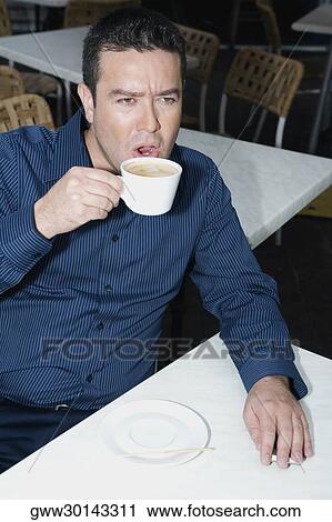 High angle view of a mid adult man drinking tea in a restaurant View Large Photo Image Stock Image - High angle view of a mid adult man drinking tea in a restaurant. Fotosearch