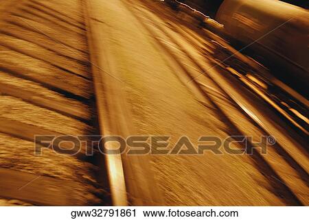 Stock Image - High angle view of a railroad track at night. Fotosearch