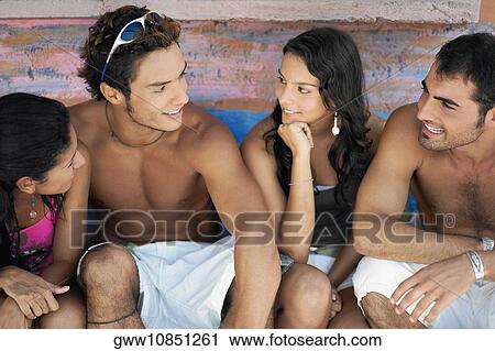 High angle view of a teenage girl and a young woman sitting with two young men View Large Photo Image Stock Image - High angle view of a teenage girl and a young woman sitting with two young men. Fotosearch