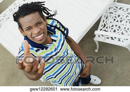 High angle view of a young man standing and smiling View Large Photo Image Stock Image - High angle view of a young man standing and smiling. Fotosearch