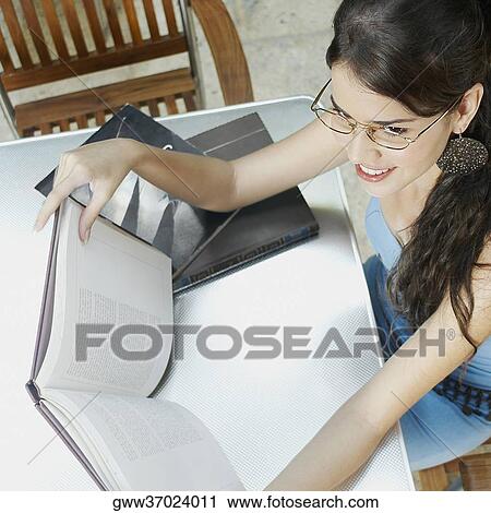 High angle view of a young woman holding a book View Large Photo Image Stock Image - High angle view of a young woman holding a book. Fotosearch