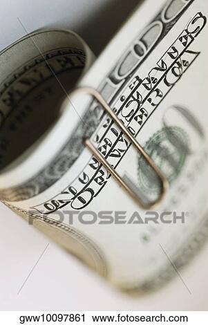 Stock Image - High angle view of one hundred dollar bills with a paper clip. Fotosearch
