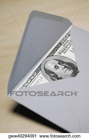 Stock Image - High angle view of one hundred dollar bill in an envelope. Fotosearch