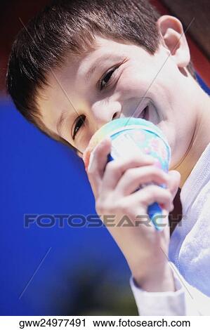 Low angle view of a boy holding an ice-cream and smiling View Large Photo Image Stock Image - Low angle view of a boy holding an ice-cream and smiling. Fotosearch