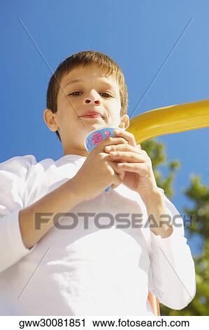 Low angle view of a boy holding an ice-cream and smirking View Large Photo Image Stock Image - Low angle view of a boy holding an ice-cream and smirking. Fotosearch