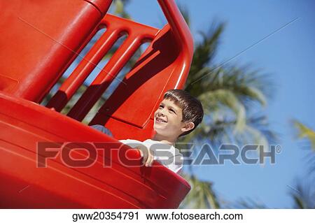 Low angle view of a boy playing on a slide View Large Photo Image Stock Image - Low angle view of a boy playing on a slide. Fotosearch