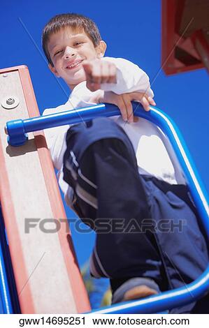 Stock Image - Low angle view of a boy standing and pointing. Fotosearch